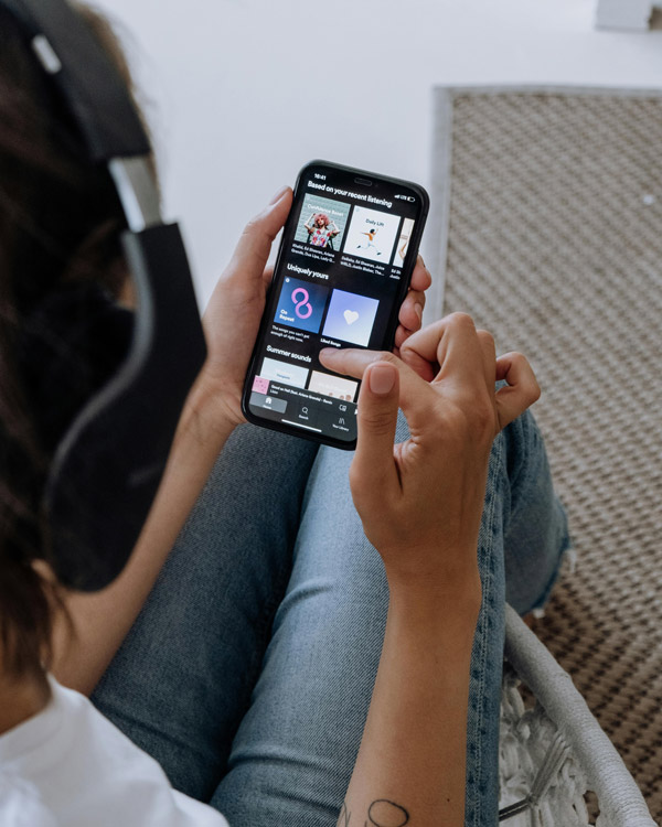Person using Spotify on a smartphone, symbolizing music discovery and the potential for independent artists to reach new audiences through targeted ads.